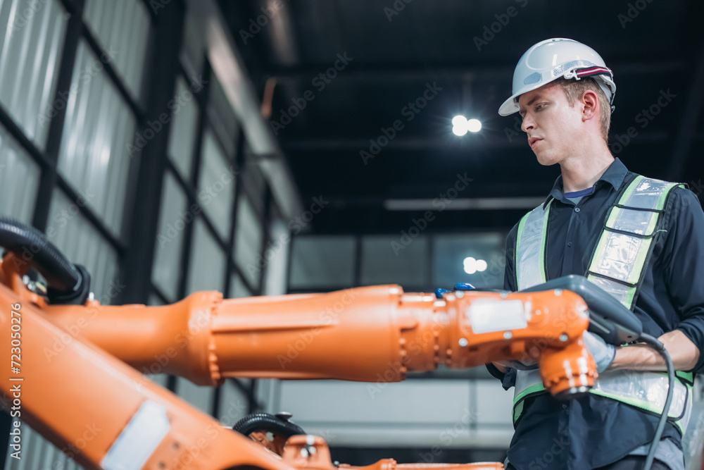 Focused technician using a control panel display to manage and automate a robotic arm in a modern factory workshop.
Focused technician using a control panel display to manage and automate a robotic arm in a modern factory workshop.