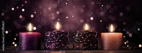 Three candles placed closely together on a flat surface, emitting soft illumination.