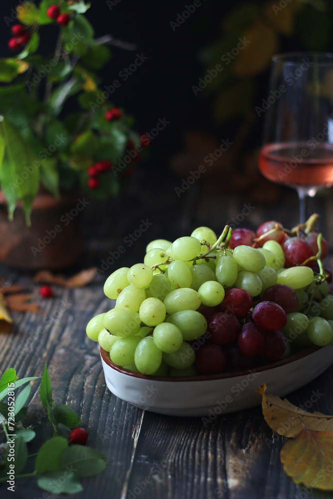 A bowl with red and green grape in rustic style