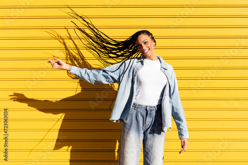 Happy young woman tossing hair in front of corrugated shutter photo