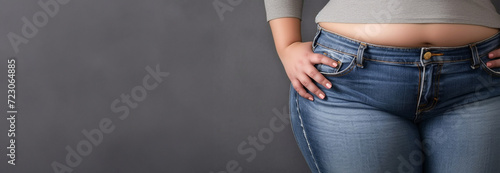 Troubled overweight woman in tight jeans clothes. Big chubby bellied in pants. Overweight person with too small clothes