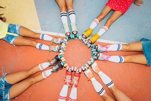 Legs of women wearing roller skates making circle at sports court photo