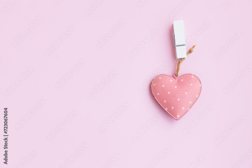 Steel pink heart hanging on a white wooden clothespin on pink background, Vintage Pink heart shape. Steel pink heart hanging on a white wooden clothespin on pink background, Vintage Pink heart shape.