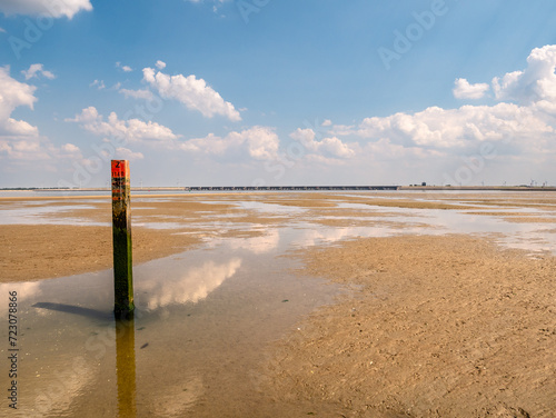 Beach pole with red top in Slijkgat near Haringvlietdam, South Holland, Netherlands photo