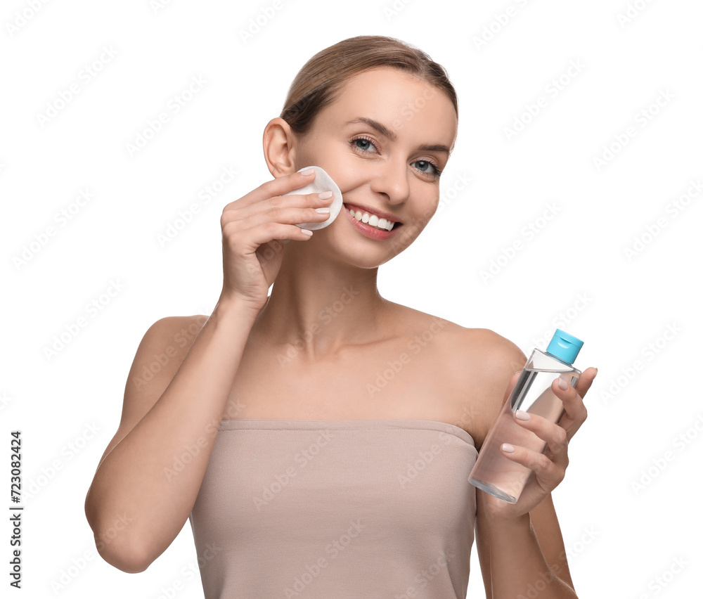 Smiling woman removing makeup with cotton pad and holding bottle on white background Smiling woman removing makeup with cotton pad and holding bottle on white background