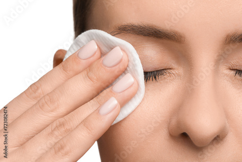 Woman removing makeup with cotton pad on white background, closeup photo