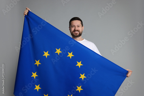 Man holding European Union flag on light grey background