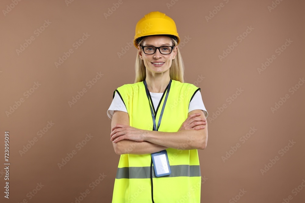 Engineer with hard hat and badge on brown background Engineer with hard hat and badge on brown background