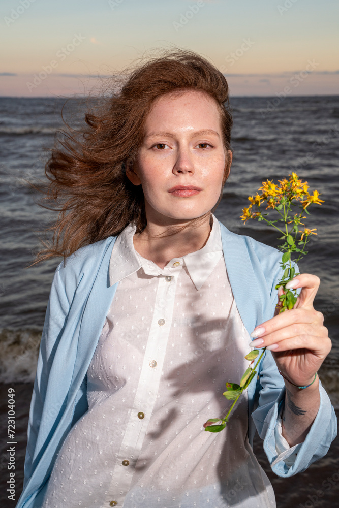 Young woman holding yellow flowers at beach Young woman holding yellow flowers at beach