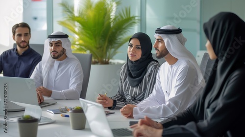 Group of middle-eastern corporate business people wearing traditional emirati clothes meeting in the office in Dubai - Business team working and brainstorming in the UAE photo