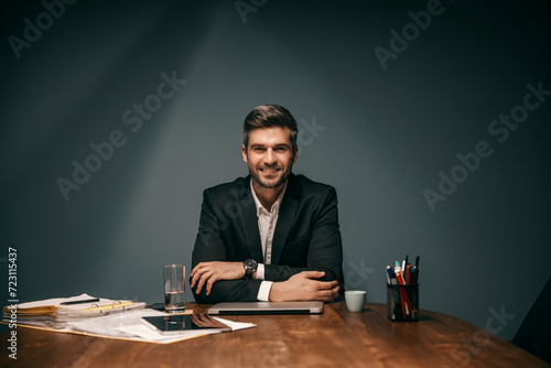 Portrait of a businessman sitting at office and smiling at the camera.