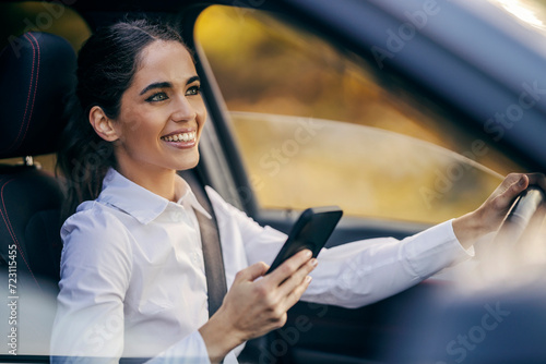 Portrait of an elegant woman driving her car and using phone.