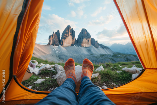 feet with sock outside the tent with a beautiful mountain landscape in the background