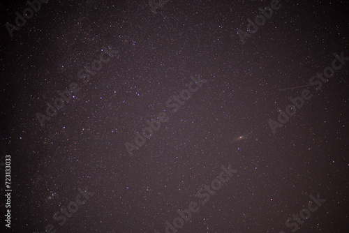 Meteor shower during perseid curent. Andromeda galaxy in the night sky