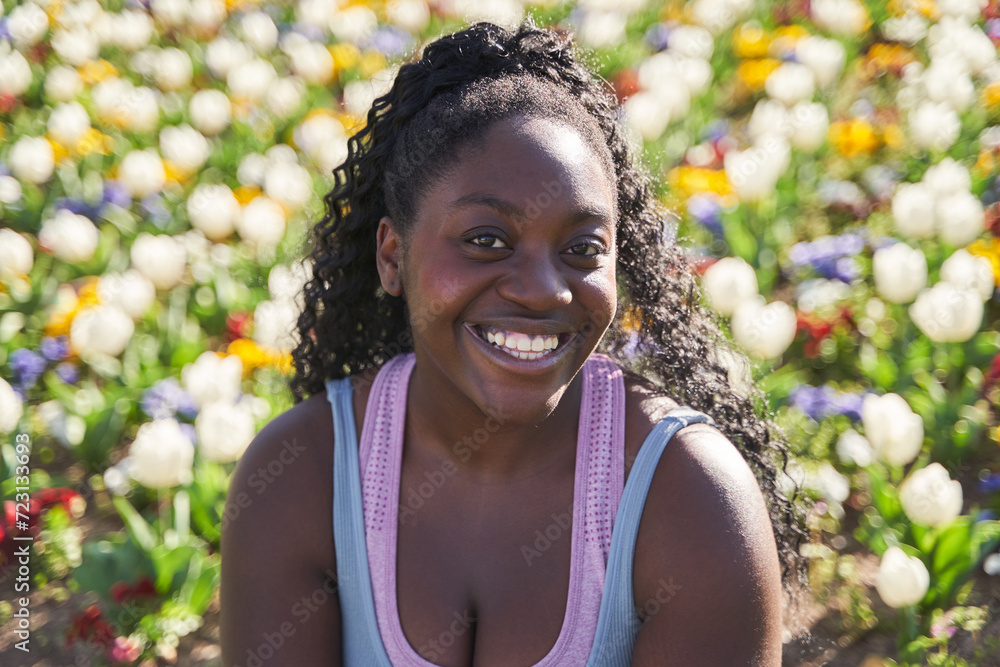 portrait of an African-American woman in an environment full of colourful flowers portrait of an African-American woman in an environment full of colourful flowers