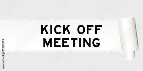 Ripped gray paper background that have word kick off meeting under torn part