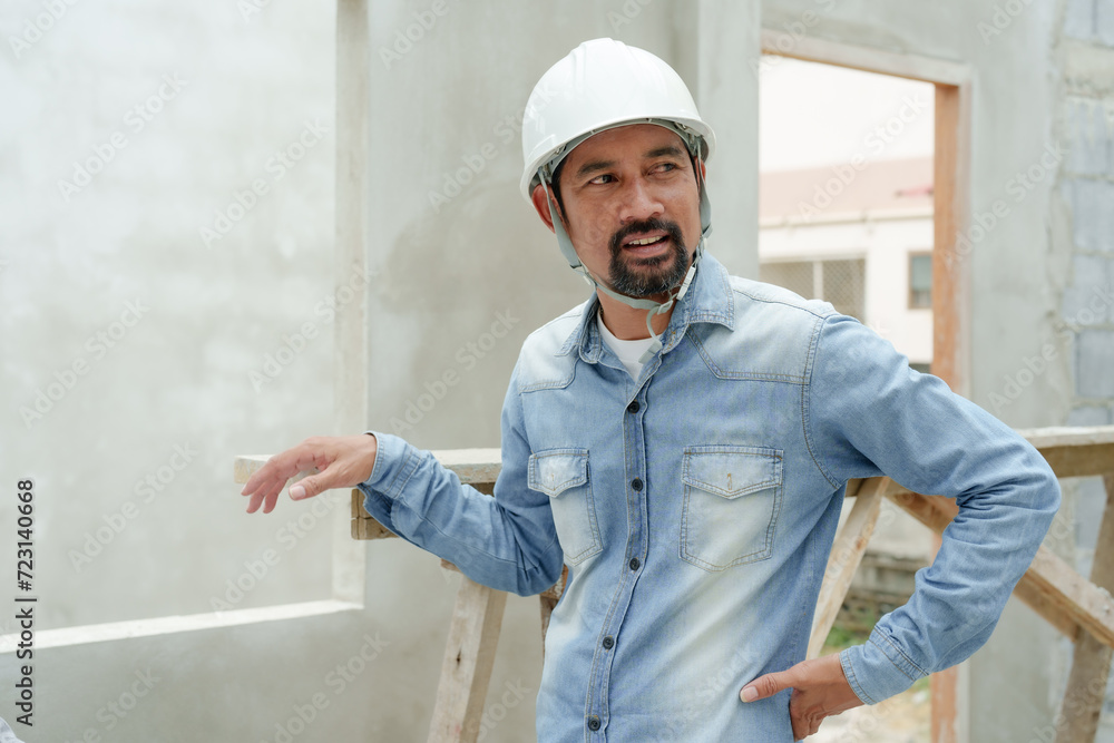 Serious construction engineer looks at architectural plans with worry. A construction supervisor is critically examining a blueprint at the job site. Serious construction engineer looks at architectural plans with worry. A construction supervisor is critically examining a blueprint at the job site.
