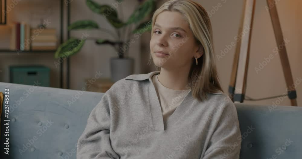 Slow motion portrait of happy young woman turning to camera and smiling sitting in cozy house in evening. Positive emotion and people concept. Slow motion portrait of happy young woman turning to camera and smiling sitting in cozy house in evening. Positive emotion and people concept.
