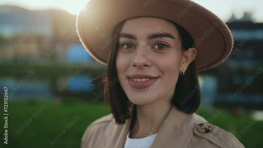 Side View of Attractive young Lady Looking at Camera Wearing Brown Hat on the Lake Background. Side View of Attractive young Lady Looking at Camera Wearing Brown Hat on the Lake Background.