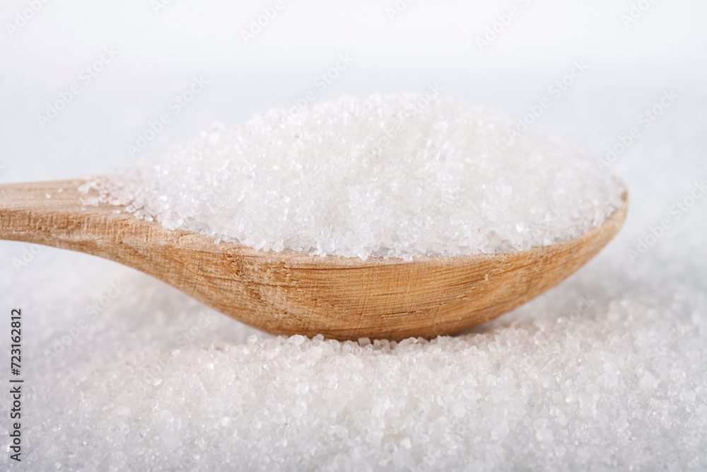 Wooden spoon with white sugar on white background Wooden spoon with white sugar on white background