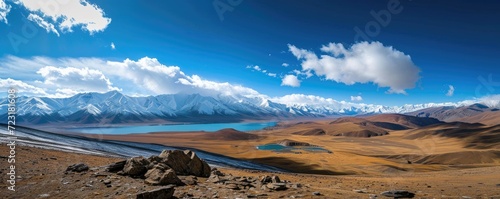 Panoramic view of the beautiful mountain landscape, blue sky and white clouds, amazing lake and snow-capped mountains.