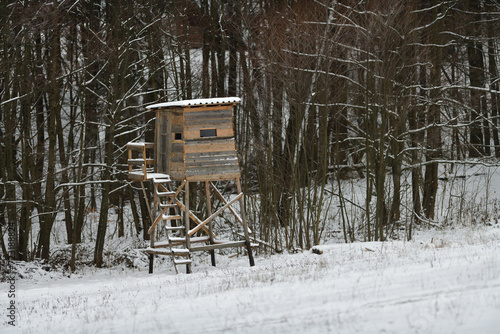 Obraz na płótnie Hunting hidden cottage from wooden in meadow near forest in winter w salonie