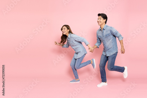 Asian couple in jeans outfit and running isolated on pink background