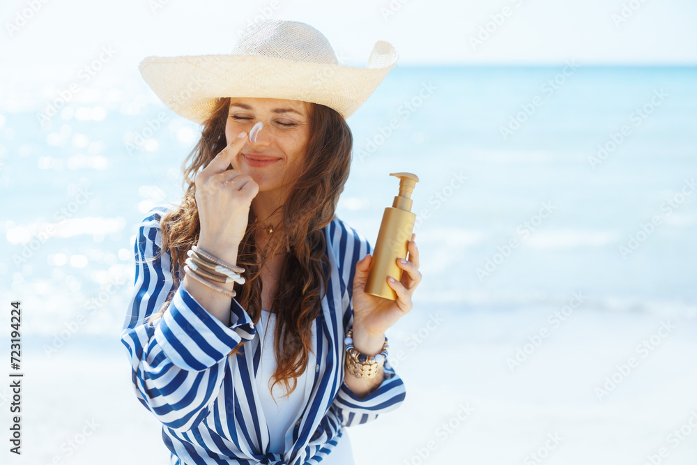 smiling modern female on beach with spf