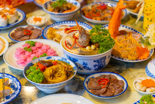 Tet tray. Full of traditional dishes. Chinese new year festival table with asian food. Vietnamese food for Tet holiday in lunar new year. Text on food meaning happy and peaceful. © CravenA