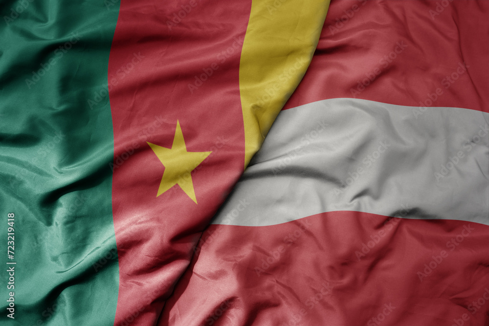 Obraz premium big waving national colorful flag of austria and national flag of cameroon .