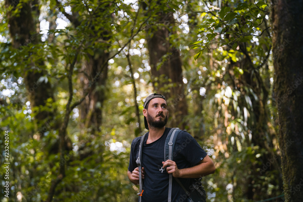 Man exploring lush forest trail with curiosity