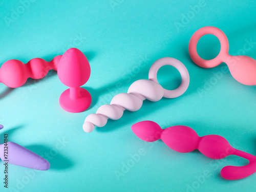 Set of pink anal plug toys over blue turquoise background