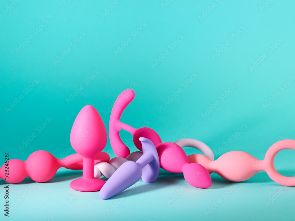 Heap of silicone sex toys over turquoise background - obrazy, fototapety, plakaty 