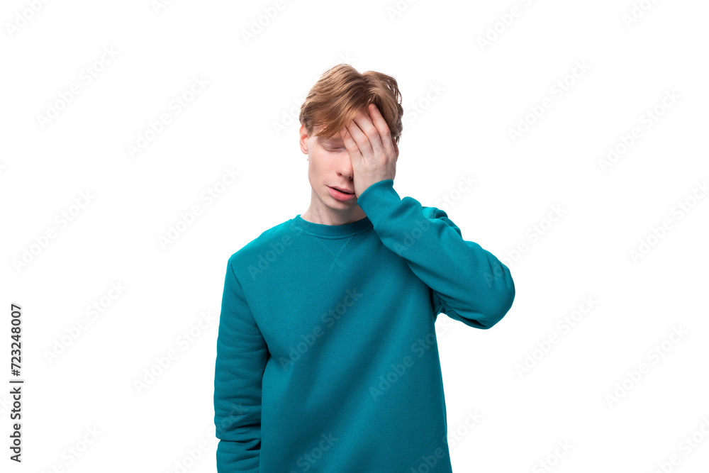 young upset handsome man with red hair dressed in a blue jacket on a white background with copy space young upset handsome man with red hair dressed in a blue jacket on a white background with copy space