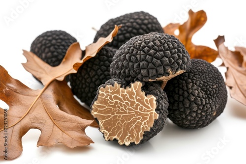 Black truffles and oak leaves in a closeup shot white background