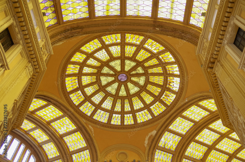 Obraz premium Run down opulent interior architecture with glass dome and roof, statues, balconies and closed shops and boutiques