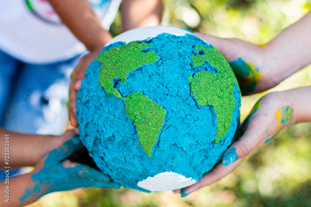 Children Holding Handmade Painted Globe in Nature Children Holding Handmade Painted Globe in Nature