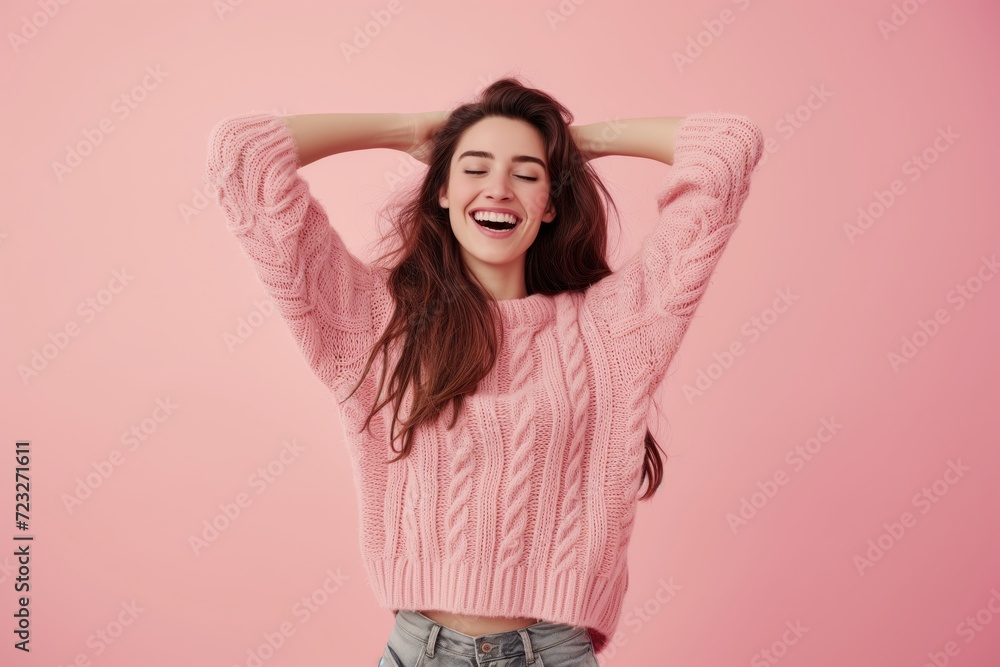 A beautiful young smiling girl on a coloured background has her hands up in the air and is laughing A beautiful young smiling girl on a coloured background has her hands up in the air and is laughing