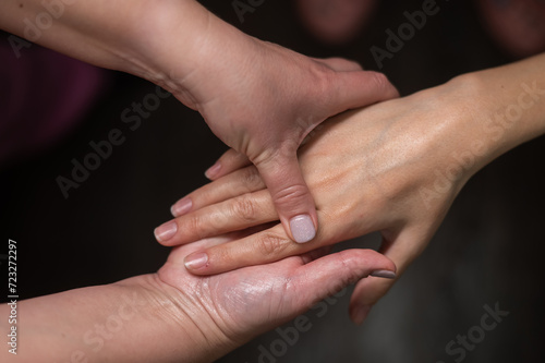 The masseuse massages the client's palms. Close-up of hands at a spa treatment.