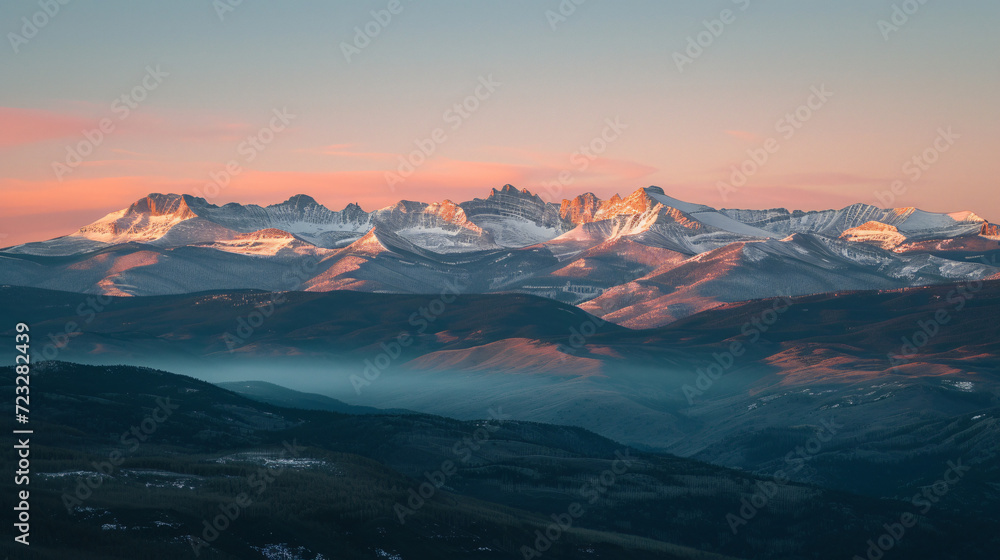 A majestic mountain range at sunset with peaks covered in snow.
