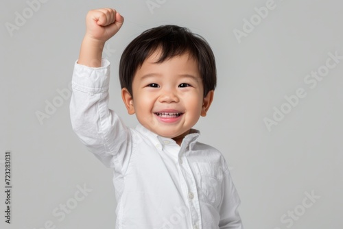 Triumphant Asian Boy, One Year Old, Celebrates With Fist Pump - Perfect Symmetrical Photo