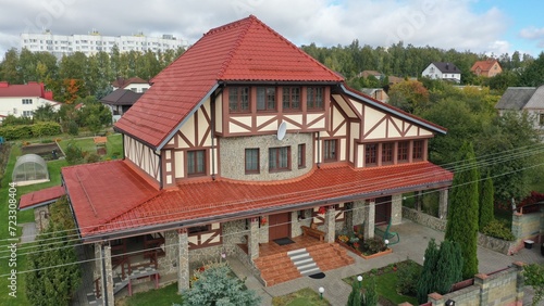 Huge expensive house, cottage in Europe in the colonial modern style of architecture with red tile roof, large windows to the street, homestead. Yard, front of the private house. © Aerial Drone Master