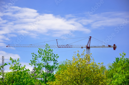 Crane over trees in blue sky