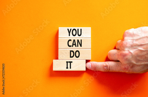 You can do it symbol. Concept word You can do it on beautiful wooden block. Beautiful orange table orange background. Businessman hand. Business motivational you can do it concept. Copy space. photo