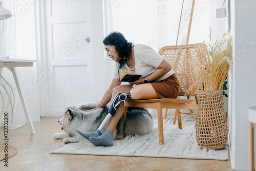 Принти на полотні Woman with prosthetic leg sitting in chair near dog in at home