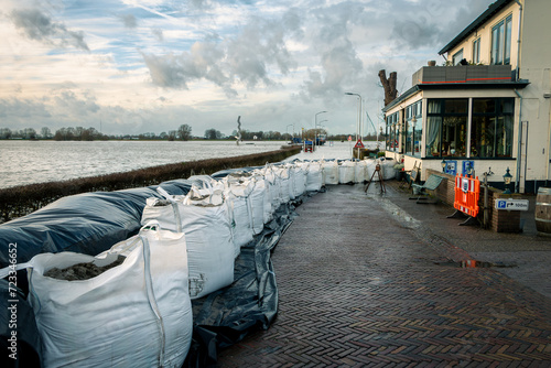Foto Sandbags for the houses in the village of Olst to prevent flooding due to the excessive rainfall and the rising water due to climate change in the rain river the IJssel