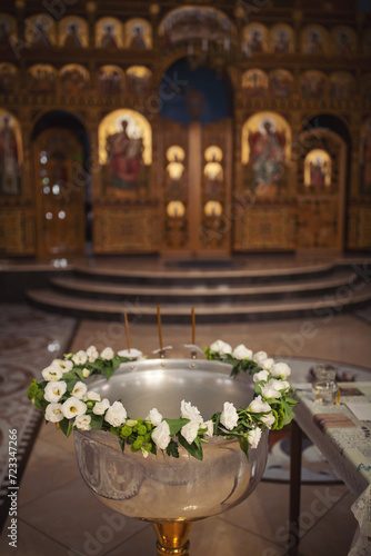 Fényképezés Metal basin (font) with flowers ornament for bathing babies during the baptismal ceremony in the temple