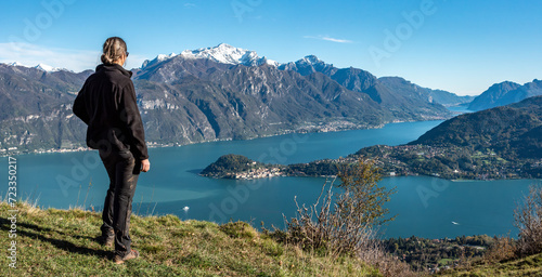 A hiker enjoying the magnificent view of Bellagio at lake Como seen from Monte Crocione