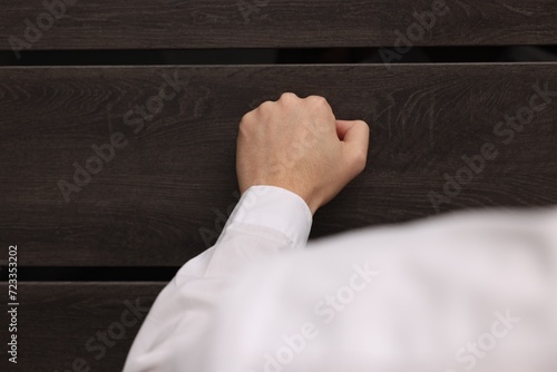 Tableau sur toile Collector knocking on door indoors, closeup view