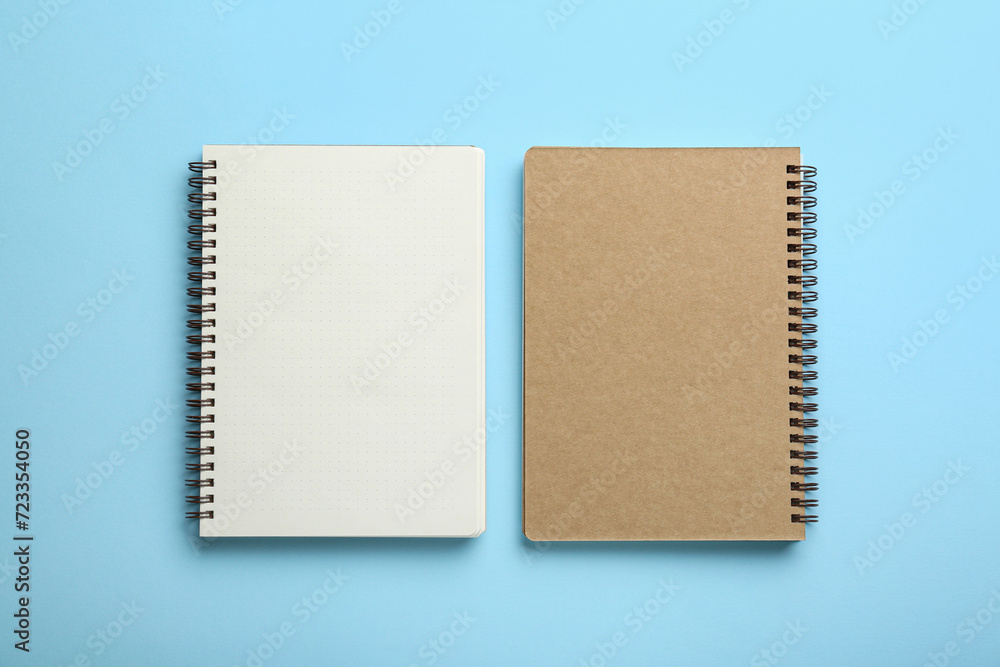 Notebooks on light blue background, top view. Space for text Notebooks on light blue background, top view. Space for text